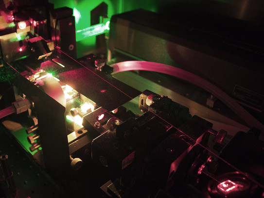 Das Bild zeigt einen leuchtenden Farbstofflaser mit offenem Gehäuse.